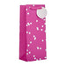 A bright pink gift bag with white polka dots and a matching pink handle, shown on a plain white background.