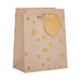 A kraft paper gift bag with scattered gold polka dots and a large blank gold oval tag on the front, featuring a matching gold ribbon handle, shown on a plain white background.