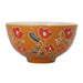An orange ceramic bowl decorated with a hand-painted floral pattern of red flowers and green leaves, shown against a plain white background.