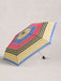 Colorful striped umbrella on a light gray background