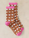 Pair of socks with sheep pattern and pink accents on a beige background