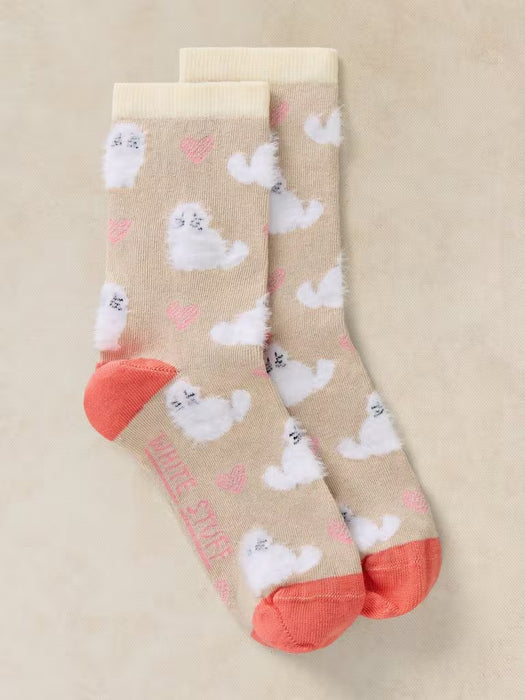 A pair of beige crew socks with a repeating pattern of fluffy white cartoon sheep and small pink hearts, finished with coral pink toes and heels.