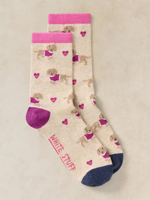Pair of socks with dog pattern and pink accents on a beige background