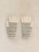 A pair of cream knit gloves with thin navy blue horizontal stripes, laid flat on a textured beige background.