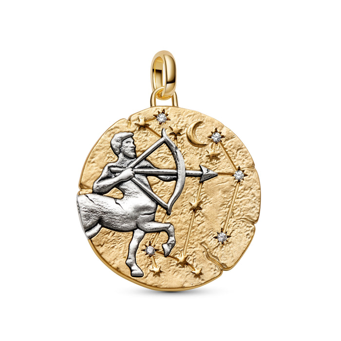 A round two-tone gold and silver pendant featuring the Libra zodiac sign, with a gold-toned textured background, a silver-toned centaur holding a bow, and small star and moon details, shown on a plain white background.