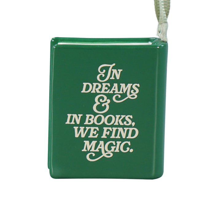 A green book-shaped ornament with the phrase 'In Dreams & In Books, We Find Magic.' in white script, shown on a plain white background with a hanging loop at the top.