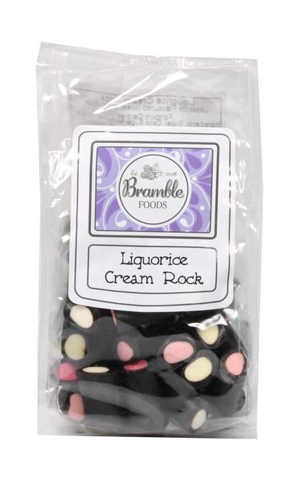 A clear plastic bag of Bramble Foods Liquorice Cream Rock, showing black licorice pieces with cream and pink pieces inside, with a white and purple label on the front.