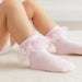 Pink baby socks with ruffles on a light background
