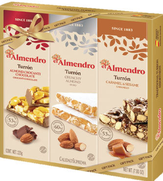 El Almendro gift pack containing three assorted chocolate bars: Turrón Almondricchi Chocolate, Turrón Crunchy Almond (60% almonds), and Turrón Caramel y Sesame. The packaging is beige with brown and white sections, decorated with almonds, chocolate pieces, and a gold ribbon.