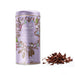 A lavender cylindrical tin of Haldsworth Luxury Hot Chocolate with botanical illustrations, shown next to a small pile of chocolate shavings on a white background.