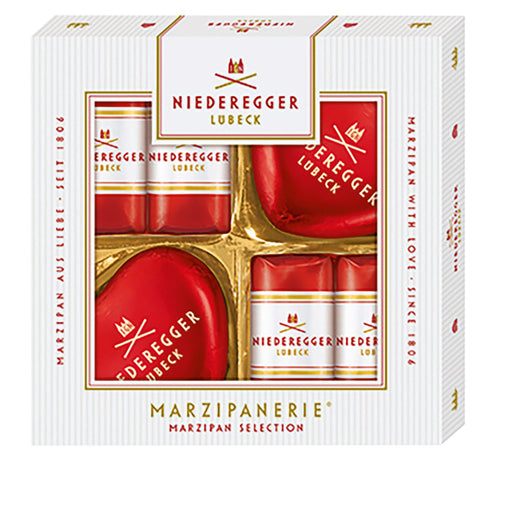 Niederegger Lubeck Marzipan Selection gift box containing heart-shaped marzipan and wrapped marzipan bars, presented in a white box with gold trim and red packaging.