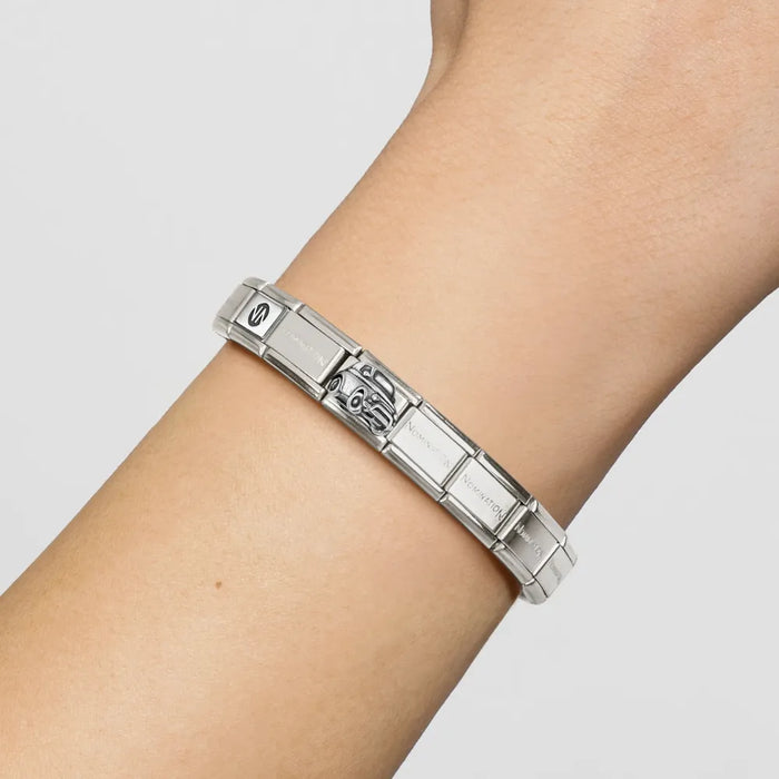 Silver bracelet on a person's wrist against a light gray background