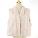 A light beige faux fur vest displayed on a cream-colored mannequin torso with a gold finial, set against a plain white background.